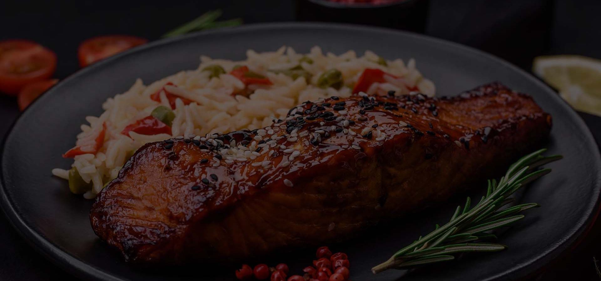 Delicious red salmon fish grilled with sauce and sesame seeds wi